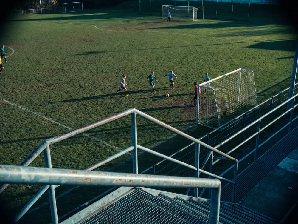 Un celular filmando el partido desde lo alto de una tribuna: se ve toda la cancha y cada jugador separado del otro.